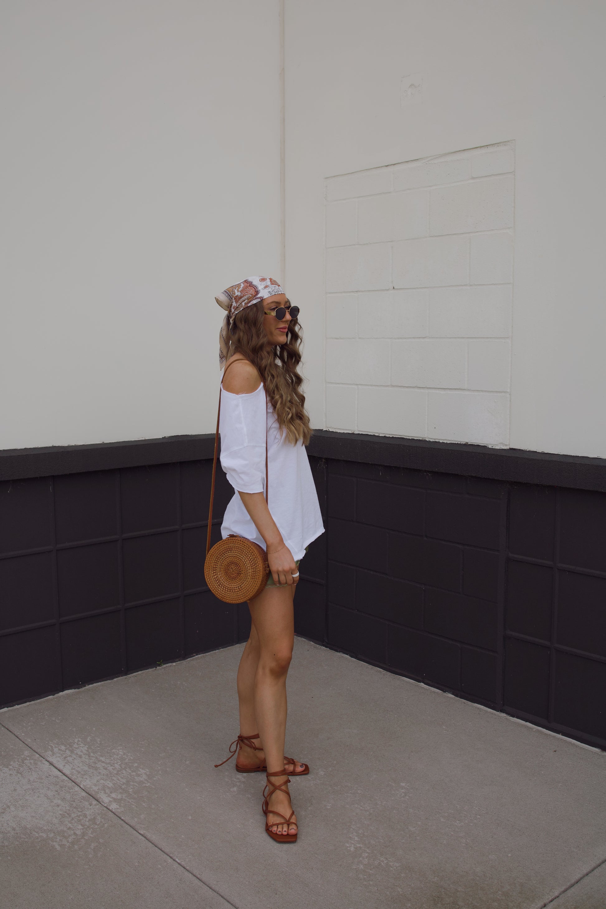 festival outfit for summer. Simple white shirt with statement shorts. Headscarf and purse for accessories